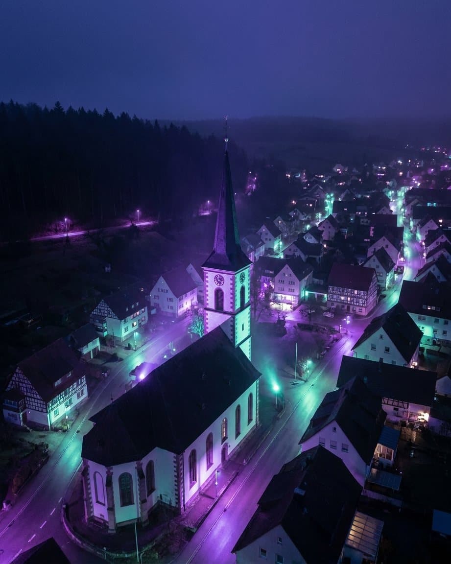 Drohnenaufnahme einer Kleinstadt in der Abenddämmerung, KI-gestützt erstellt